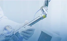 Medical instrument and gloved hand in a clinical equipment setting.